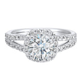 Cushion halo showcases a round solitaire, enhanced by a modern split diamond-studded shank.