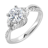 Nature-inspired three-stone ring with an intertwined design of pavé diamonds and polished metal.